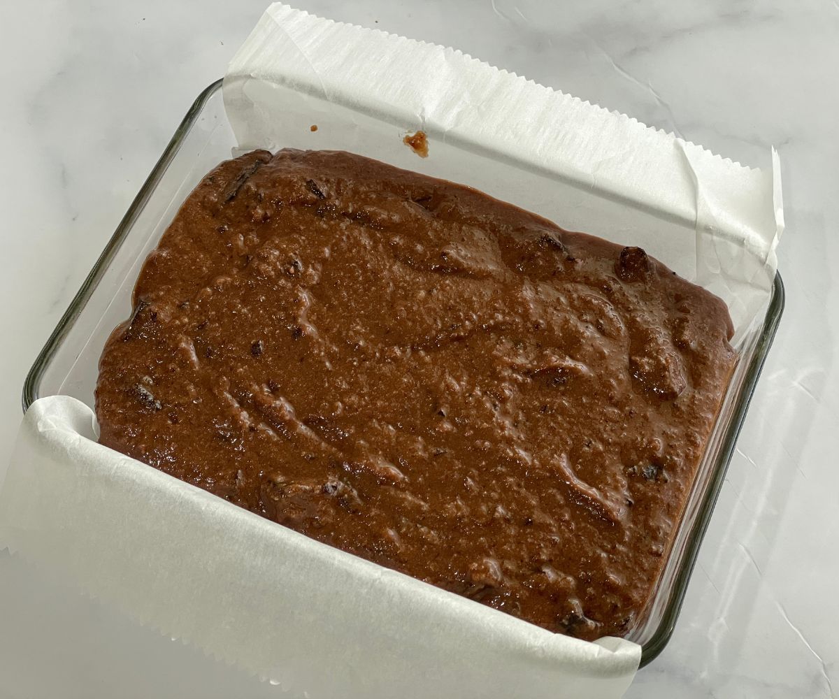 A tray is filled with vegan brownie batter.