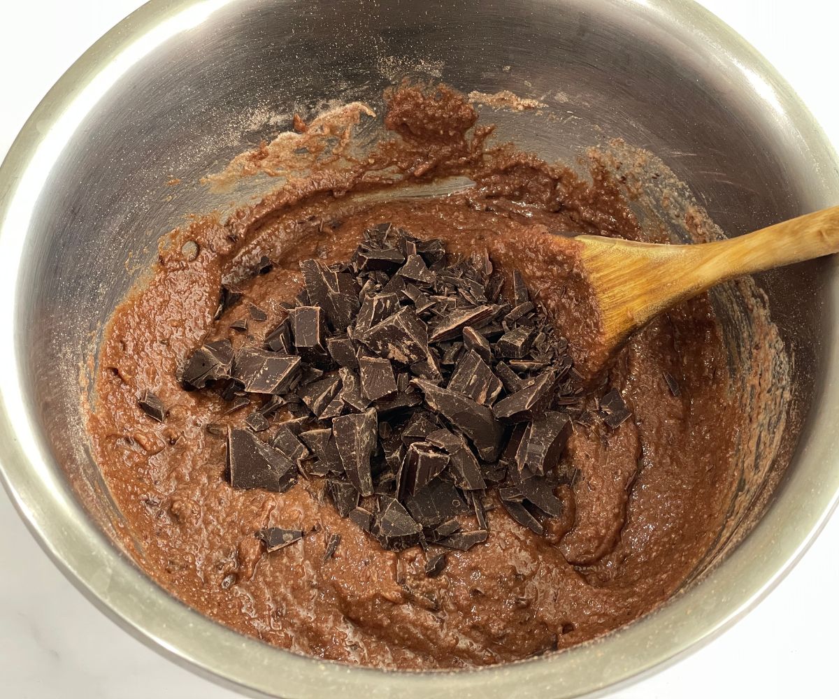 A bowl has vegan brownie mix and vegan chocolate.
